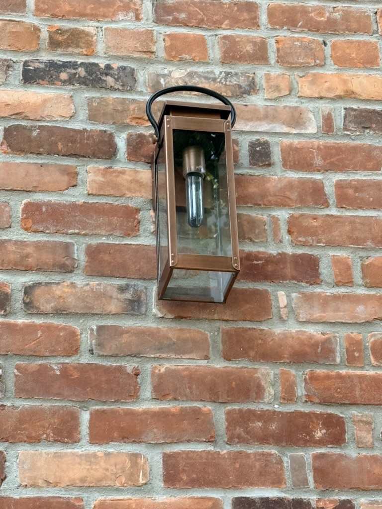 The original copper lantern mounted against Homestead’s brickwork.